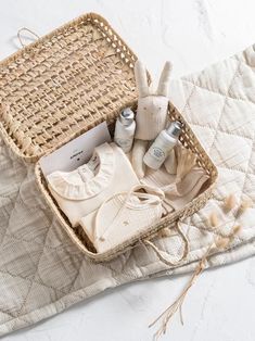 a wicker basket filled with personal care items on top of a quilted blanket