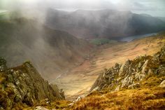 the mountains are covered in clouds and grass