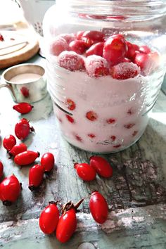 a jar filled with cherries sitting on top of a table