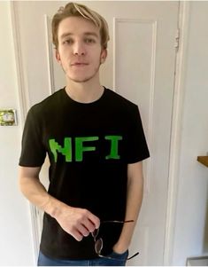 a young man is standing in front of a door wearing a t - shirt that says n f i