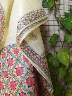 the fabric is colorfully decorated and has flowers on it, as well as green leaves