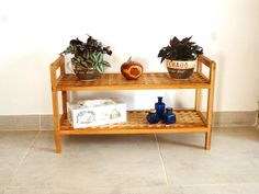 two potted plants sitting on top of a wooden shelf