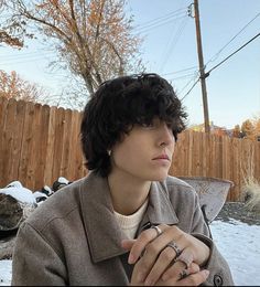 a woman sitting in the snow with her hand on her chest