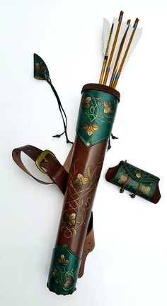 an umbrella made out of leather and decorated with flowers, leaves and arrows is sitting on the floor