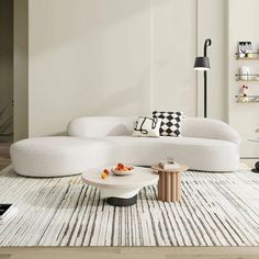 a modern living room with white furniture and rugs on the floor, including a large sectional sofa