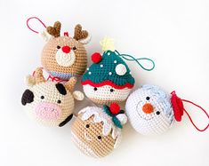 four crocheted christmas ornaments are arranged on a white surface