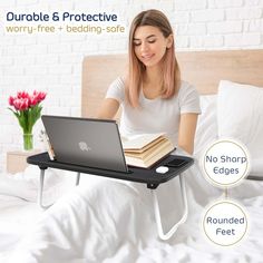 a woman sitting on a bed with a laptop and books in her lap top tray