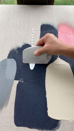 someone using a paint roller to paint an area rug with blue, pink and white colors