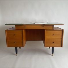 a wooden desk with two drawers and a glass top on one side, in front of a white background