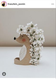 a ceramic hedge with white flowers on its head