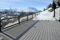 there is a snow covered mountain in the background and a deck with railings on it