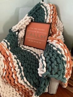 an orange and white blanket sitting on top of a bed