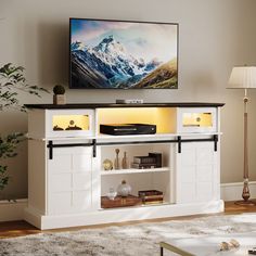 a flat screen tv mounted to the side of a white entertainment center in a living room