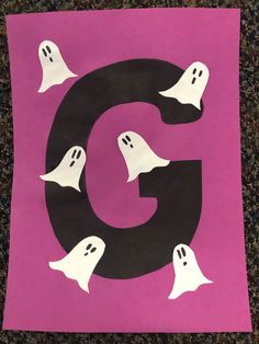 the letter g is made out of paper with ghost's on it