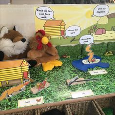 two stuffed animals sitting on top of a table next to a sign that says rooster