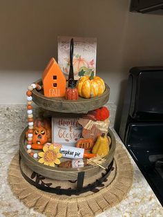 three tiered trays with decorations on top of a kitchen counter