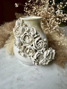 a white vase with some flowers in it