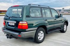 a green suv parked in a parking lot