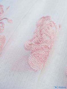 closeup of pink crochet on white fabric