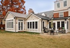 a house that has a patio in front of it and an outside dining area on the other side