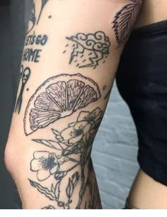 a woman's arm with tattoos on it, and an orange in the middle