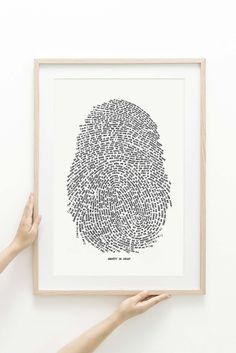 two hands holding up a framed print with the word fingerprint on it