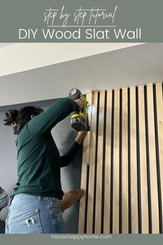 a woman sanding wood on the side of a wall