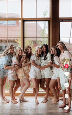 a group of young women standing next to each other in front of a large window