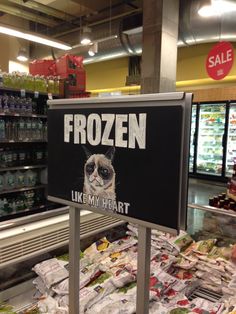 a sign that says frozen like my heart in front of a store filled with food