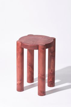 a small wooden stool made out of wood with one leg bent down and the other sitting on it's side