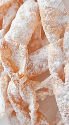 powdered sugar coated doughnuts on a white plate, ready to be eaten