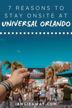 a person holding up a card with the words 7 reasons to stay onsite at universal