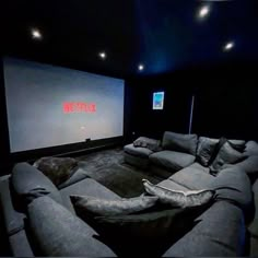 an empty theater room with two couches and a projector screen