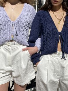 two women wearing white shorts and blue sweaters