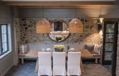 a dining room with stone walls and white chairs