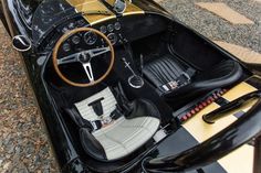 the interior of an old fashioned sports car is black and white with gold trims