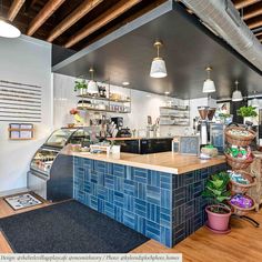 the inside of a restaurant with blue tiles on the counter and wood flooring in front of it