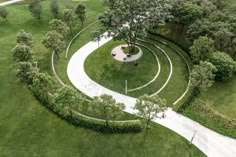 an aerial view of a circular garden in the middle of a grassy area with trees