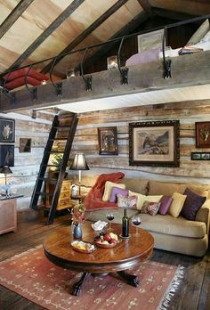 a living room filled with lots of furniture and pictures on the wall next to a ladder