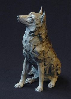 a statue of a dog sitting on a black background