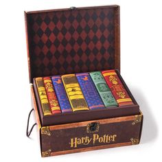 a harry potter book set sitting in a wooden box on top of a white surface