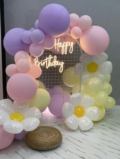 a birthday decoration with balloons and flowers