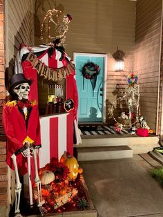 halloween decorations on the front porch of a house with skeletons and pumpkins in it