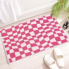 a pair of slippers sitting on the floor next to a pink and white rug