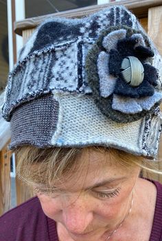 "This beautiful hat is made from recycled wool sweaters, that have been felted so they are thick and cozy.  The hat is beautiful black and white Icelandic coordinated wool. The hat has a removable felted flower with a vintage button in the center.  This pin can be removed, placed at the front or side of the hat, or worn as a matching pin on your coat.   Be sure to check out the mittens that match this hat, sold separately in my shop. Lined with grey fuzzy fleece that stretches so one size fits all adults, without slipping or pinching. Please feel free to convo me with any questions or comments at anytime. Sized: Medium ladies hat, one size fits all. Measurements:  Height of hat: 5\" (13 cm) Measurement around the hat: 26\" (66 cm) Hand wash, air dry flat." Hiking Vest, Recycled Wool Sweater, Market Art, Customer Gifts, Ladies Hat, Felt Gifts, Wool Mittens, Wool Art, Cute Hats