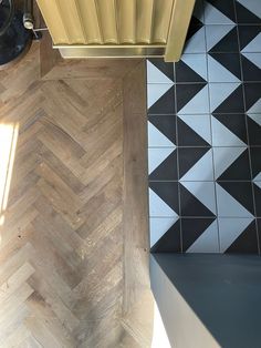 an overhead view of a kitchen floor with black and white tiles on the walls, and a yellow stove top