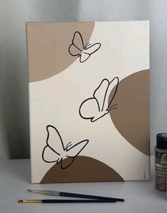 a painting with two butterflies on it next to some paint