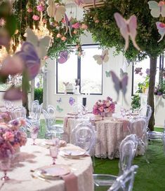 a room filled with lots of tables and chairs covered in pink flowers next to a window