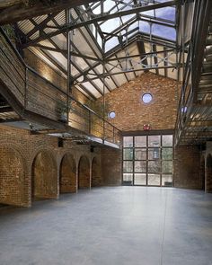 an empty room with exposed brick walls and arched doorways on either side, surrounded by arches