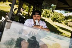 a man sitting on the back of a golf cart with his hand in his mouth